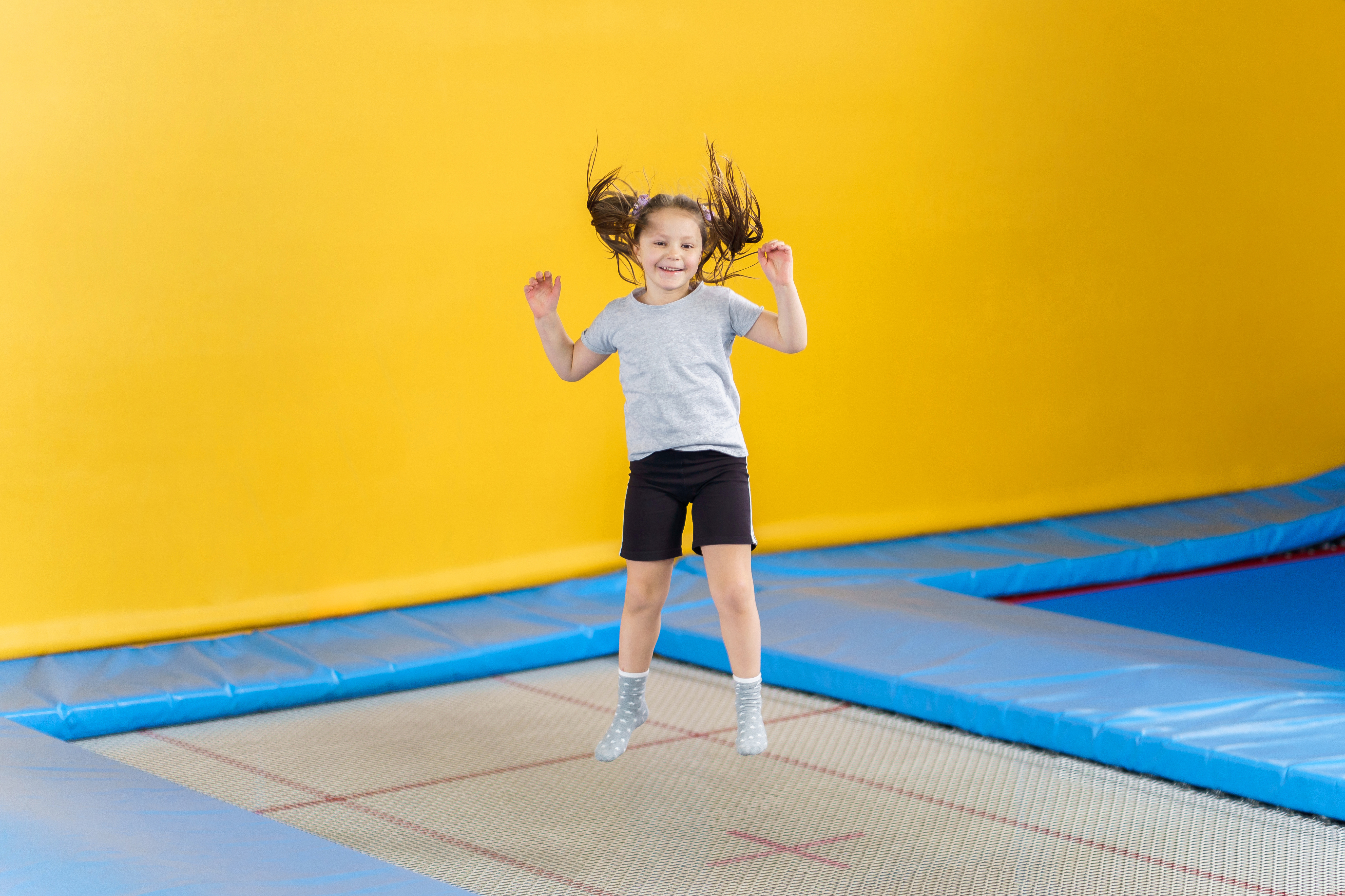 Glückliches kleines Mädchen springt auf einem Trampolin